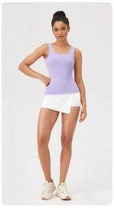 Gros plan du débardeur de yoga lilas et de la jupe de tennis blanche