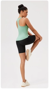 Set sportivo da donna con canotta verde chiaro e pantaloncini da ciclista neri per yoga