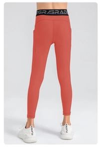 Detail of coral orange high-waisted leggings with side pockets and UPGRADE waistband