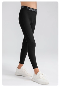 Gros plan sur un legging de sport garçon avec ceinture jacquard et texte UPGRADE