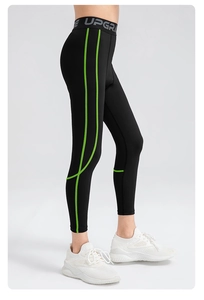 Detail of boys' sports leggings with lime green side stitching and elastic waistband