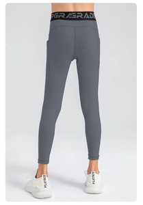 Detail of high-waisted gray kids compression leggings with UPGRADE waistband print