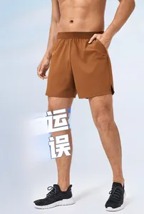 Dettaglio dei pantaloncini da corsa marrone caramello con vita elastica e spacco laterale