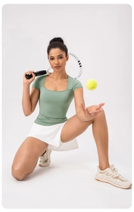 Dettaglio del top sportivo a scollo quadrato e gonna da tennis in verde salvia e bianco
