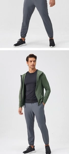 Detail view of men's olive green zip-up sports jacket and gray joggers with cuffed ankles