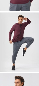 Detail of burgundy zip-up hooded jacket and grey joggers for men sports training
