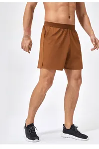 Dettaglio dei pantaloncini sportivi marroni con vita elastica e spacco laterale