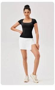 T-shirt sportiva nera con scollo quadrato e gonna da tennis bianca aderente