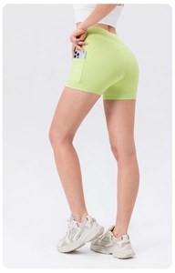 Detail view of high-waisted yoga shorts in light green with functional side phone pocket