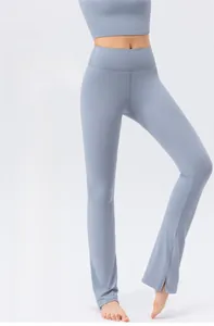 Detail of high-waist yoga pants featuring side slit hem and slim fit flared design