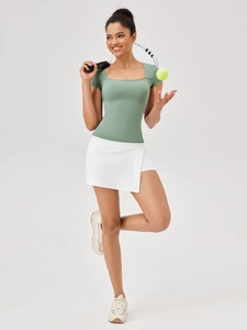 T-shirt sportiva da donna con scollo quadrato verde salvia e gonna da tennis bianca