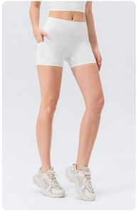 Close-up of white high-waisted yoga shorts with functional side pocket and elastic fabric