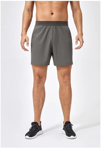 Dettaglio dei pantaloncini sportivi grigio scuro da uomo in tessuto traspirante con elastico