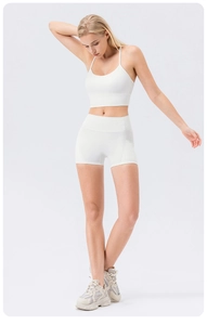 Full body view of white high-waist yoga shorts and matching U-neck sports bra on model