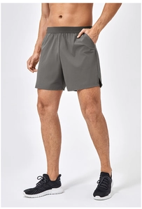 Dettaglio dei pantaloncini grigi fitness da uomo con vita elastica e spacco laterale sport