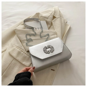 Detail of silver chain shoulder bag with sparkling rhinestone buckle on premium leather