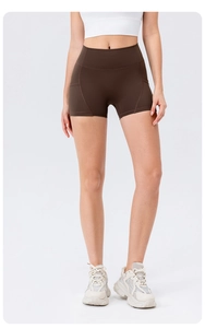 Close-up of high-waisted fitness shorts in dark brown with functional side pockets