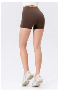Detail view of brown high-waist yoga shorts featuring side pocket and peach lift design