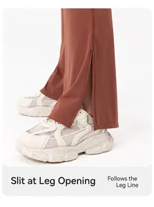 Close-up of rust red flared yoga pants featuring side slit hem and platform sneakers