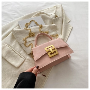 Close-up of pink crossbody bag with gold geometric interlocking buckle and chain strap