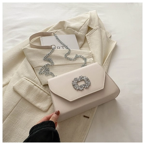 Detail of off-white crossbody bag with oversized rhinestone square buckle and chain strap