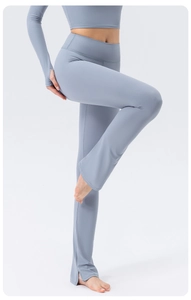 Detail of high-waisted flared yoga pants showing side slits and elastic sport fabric