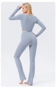 Detail of high-waisted flared yoga pants with side slits and sculpting fit in light blue