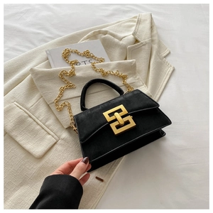 Close-up of interlocking gold buckle and metal chain strap on a black matte crossbody bag