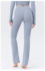 Rear view of high waisted flared yoga pants in dusty blue with a body-shaping fit