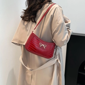 Red crocodile pattern shoulder bag for women with golden bow buckle on beige coat
