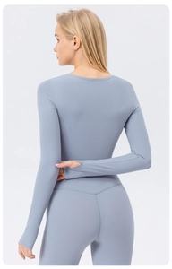 Close-up of gray-blue long sleeve yoga top featuring thumb holes and high-rise leggings