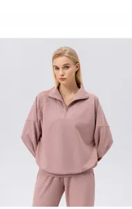 Detail of half-zip collar and shoulder seams on women's pink athletic sweatshirt