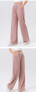 Detail of high-waisted mauve wide-leg sweatpants featuring drawstring waist and side pockets
