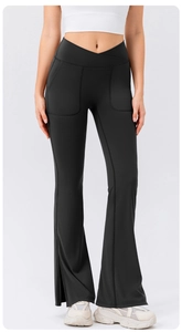 Detail view of black high waist cross-over yoga flare pants with side slits and pockets