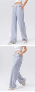 Detail view of light blue high-waisted wide-leg sweatpants with white drawstring and pockets