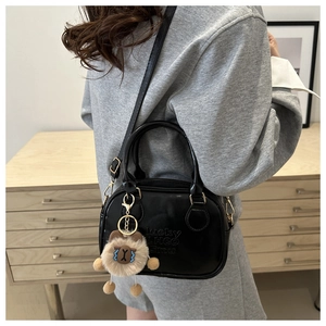 Detail of black leather bowling bag with lucky LHCO smu embossing and cute sheep charm