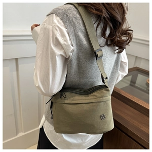 Olive green waterproof nylon crossbody bag with adjustable wide strap and metal logo