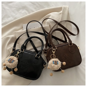 Detail of vintage bowling bags in black and coffee with cute plush sheep charms