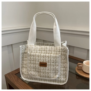 Detail of tweed tote bag with gold thread weave and Jingpin leather patch on front pocket