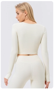 Detail of off-white long sleeve yoga crop top showing slim fit high elasticity fabric