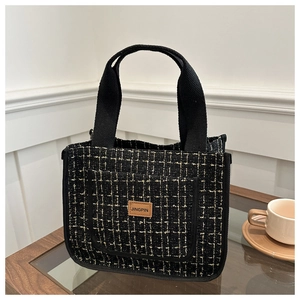 Detail of tweed tote bag with gold stitching, front pocket, and leather JINGPIN label