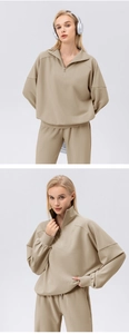 Detail of khaki half-zip sweatshirt and pants set with soft cotton knit texture