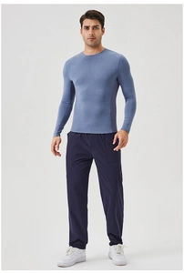 Full body shot of a man wearing blue quick-dry long sleeve gym shirt and navy sport pants