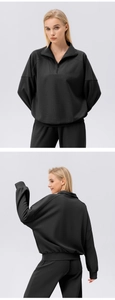 Detail of black half-zip sports sweatshirt set showing ribbed cuffs and knit texture