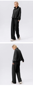 Detail view of black high-waisted wide-leg sweatpants and matching zip-up sweatshirt