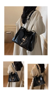 Detailed view of black faux leather tote with metal chain strap and twist lock