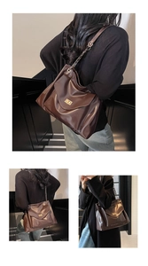 Detail of dark brown faux leather tote with golden twist lock and metal chain strap