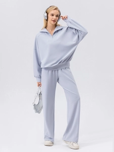 Women's light blue half-zip sports tracksuit with loose hoodie and wide-leg jogger pants