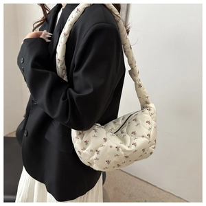 Détail du sac hobo en nylon matelassé blanc avec imprimé floral et large bandoulière souple