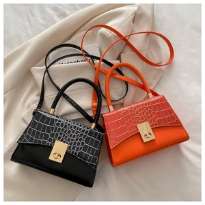 Detail of square crossbody bags featuring crocodile texture flap and gold metal twist lock